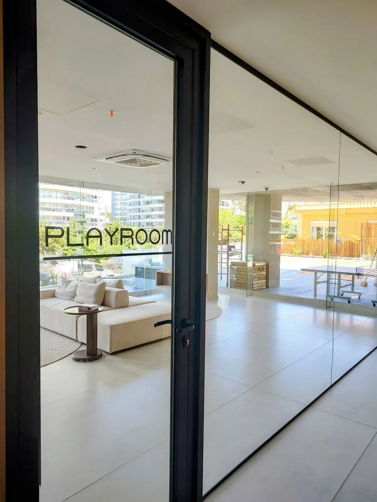 Amplia sala de juegos vidriada y climatizada, con sillones y áreas de esparcimiento para toda la familia.