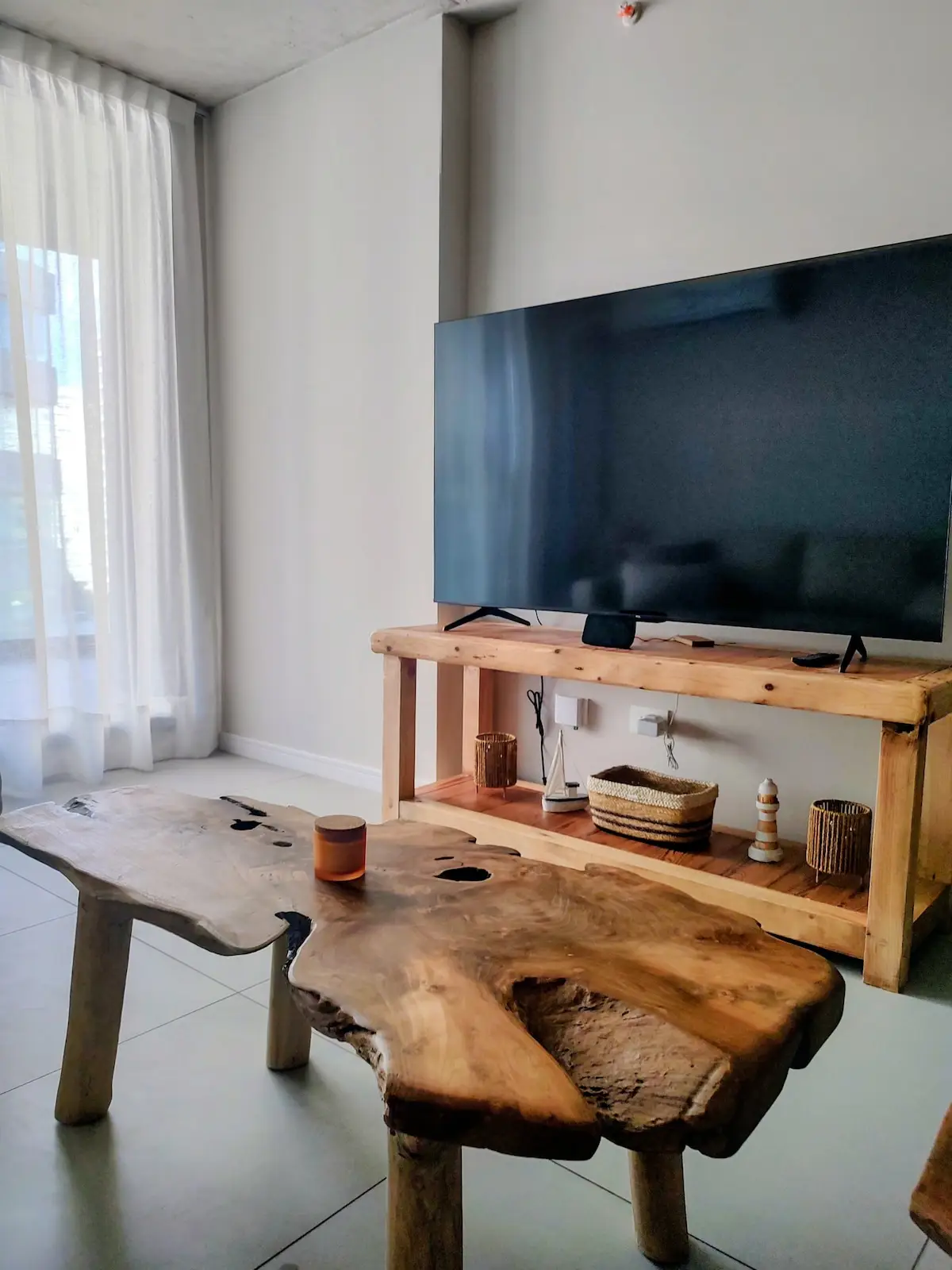Mesa ratona de madera maciza en una sola pieza, de estilo rústico-elegante, en el living.
