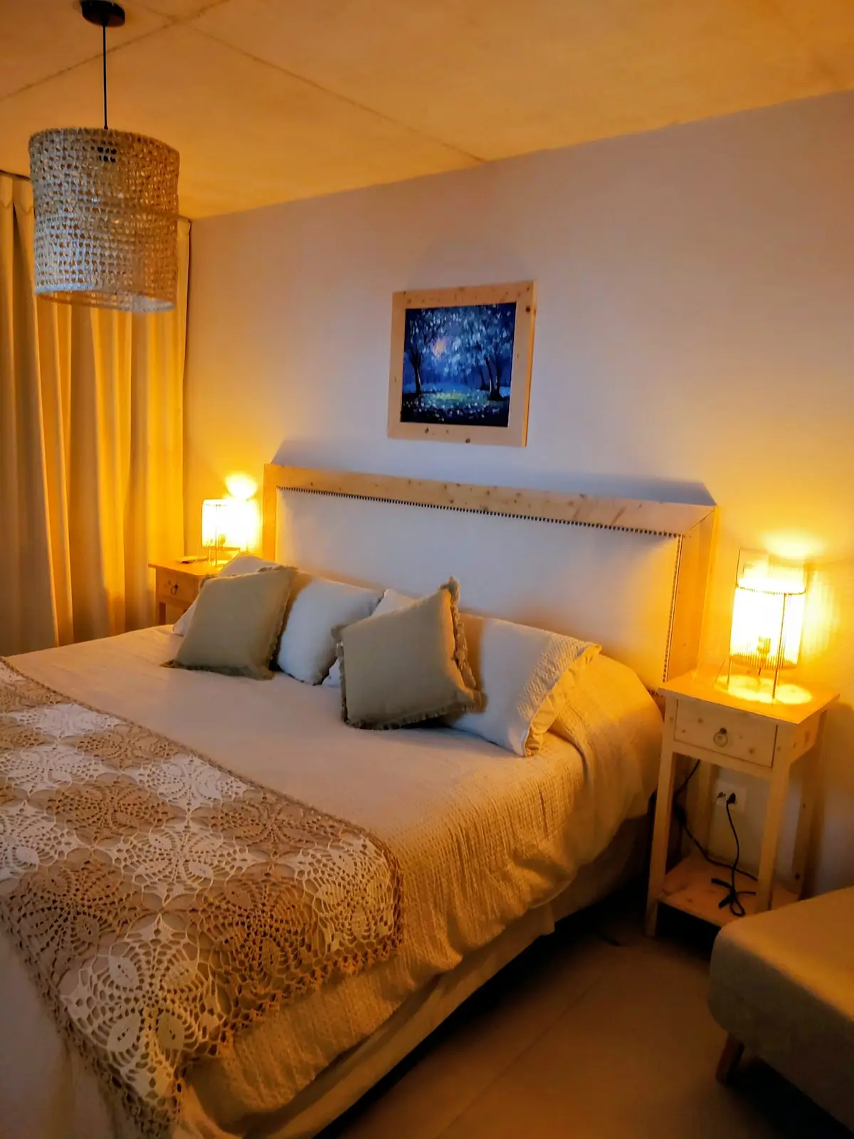 Dormitorio principal con cama Super King, decoración artesanal con mantas tejidas y cojines de textura orgánica.